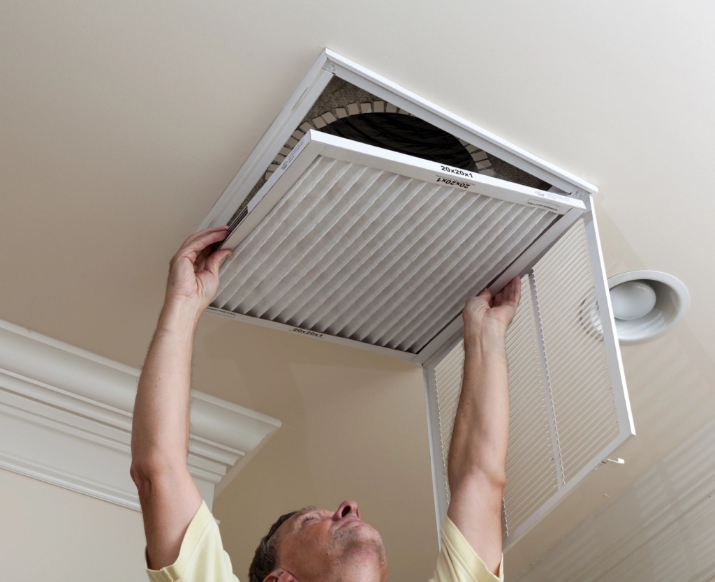 Man replacing a filter on am air vent